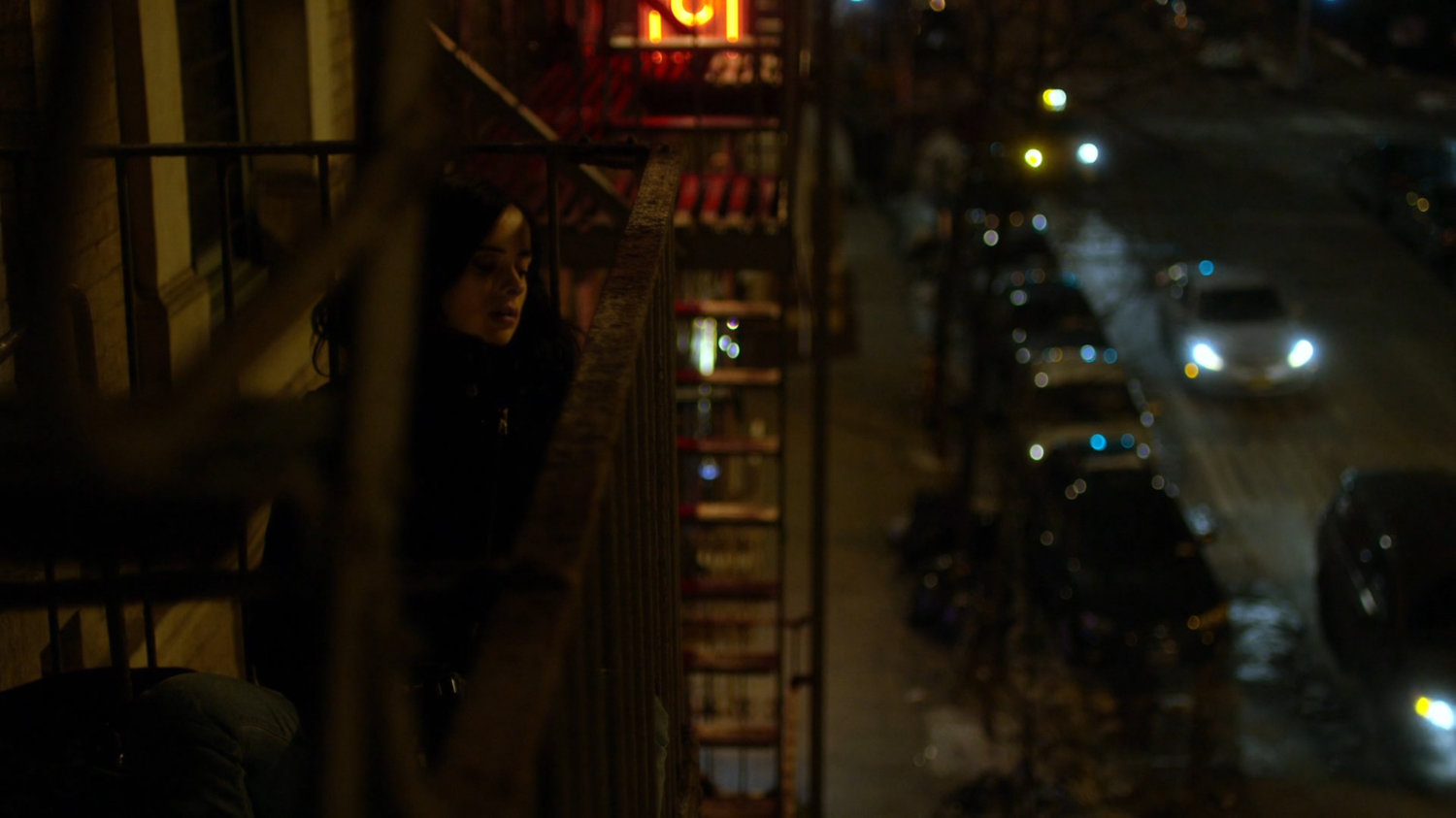 Jessica on fire escape across from Luke's bar.