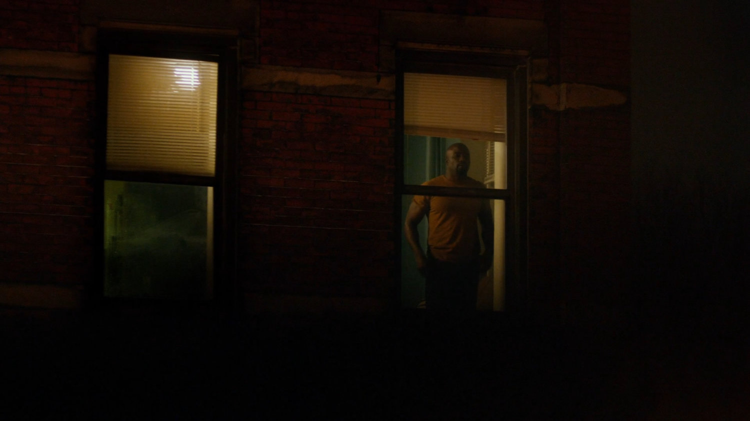 Luke Cage in the window of his apartment.