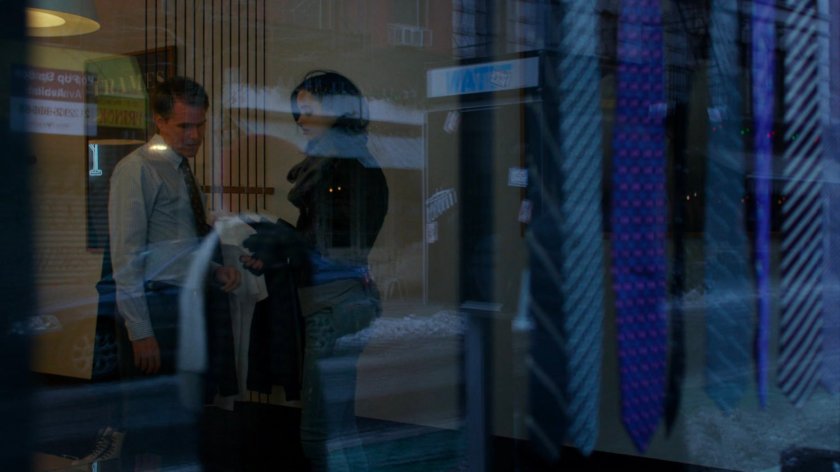 Jessica talking to man inside of tie shop.
