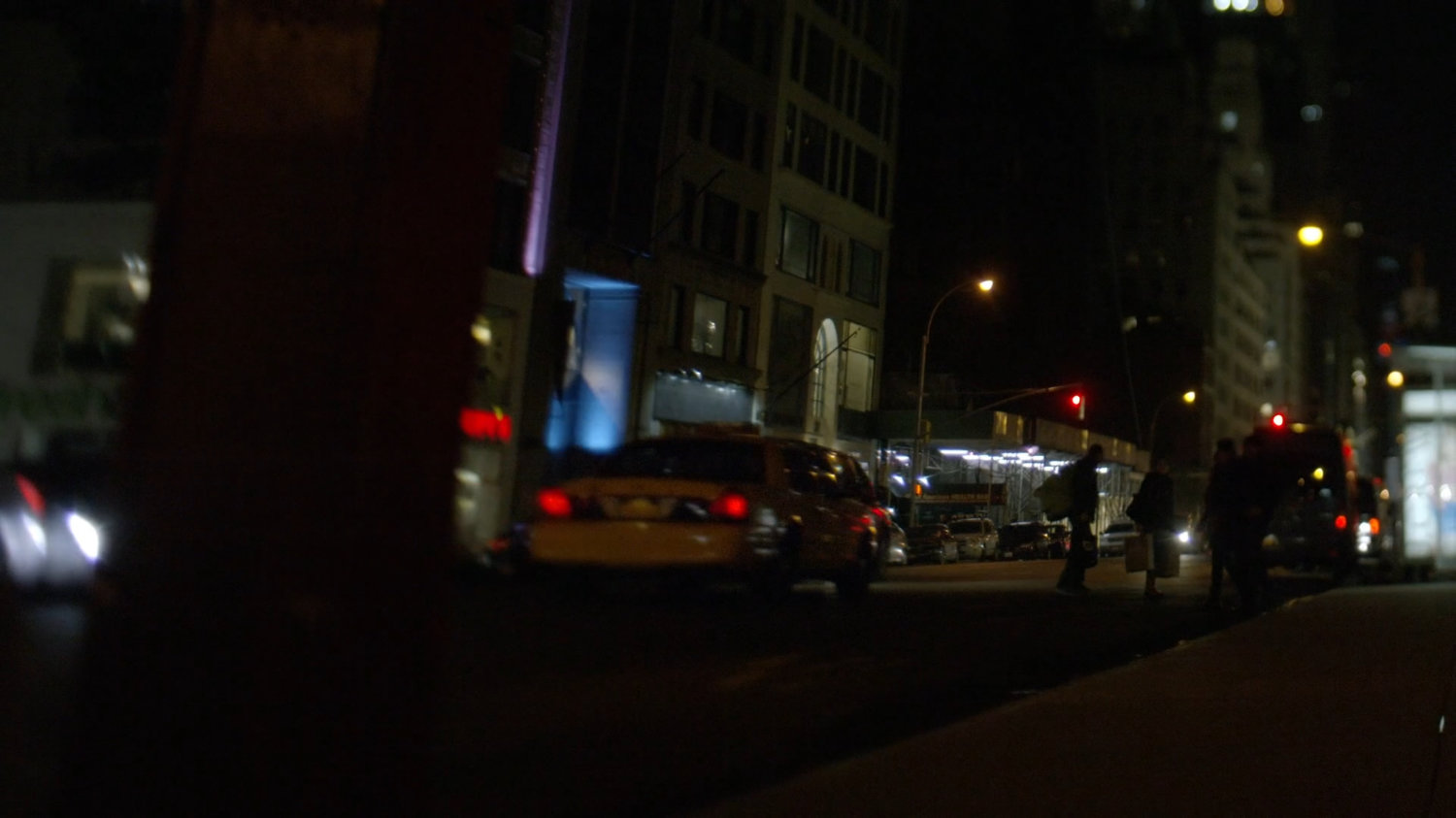 Taxi driving away on street having turned corner.