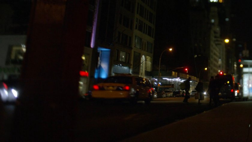 Taxi driving away on street having turned corner.