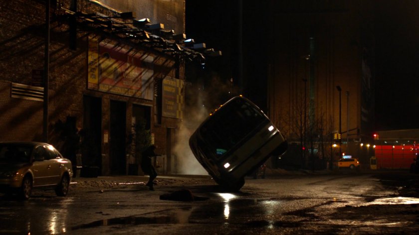 Bus flipping over on nighttime street.
