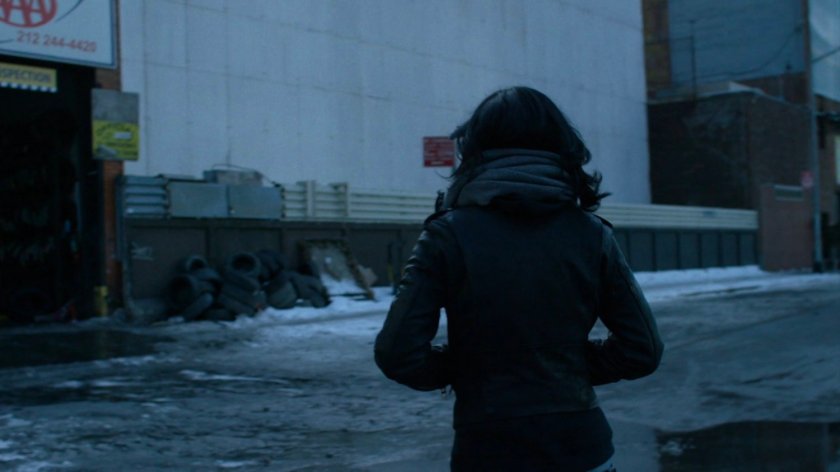 Jessica walking towards auto repair shop.