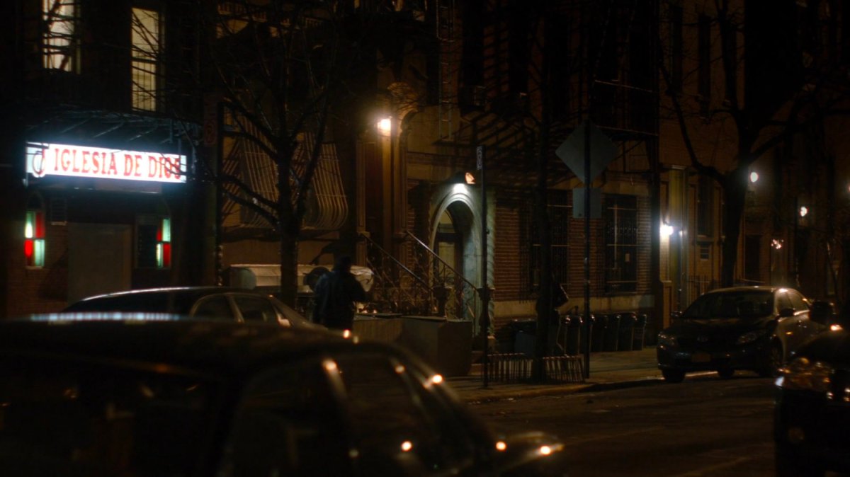 Jessica walking along a sidewalk at night.