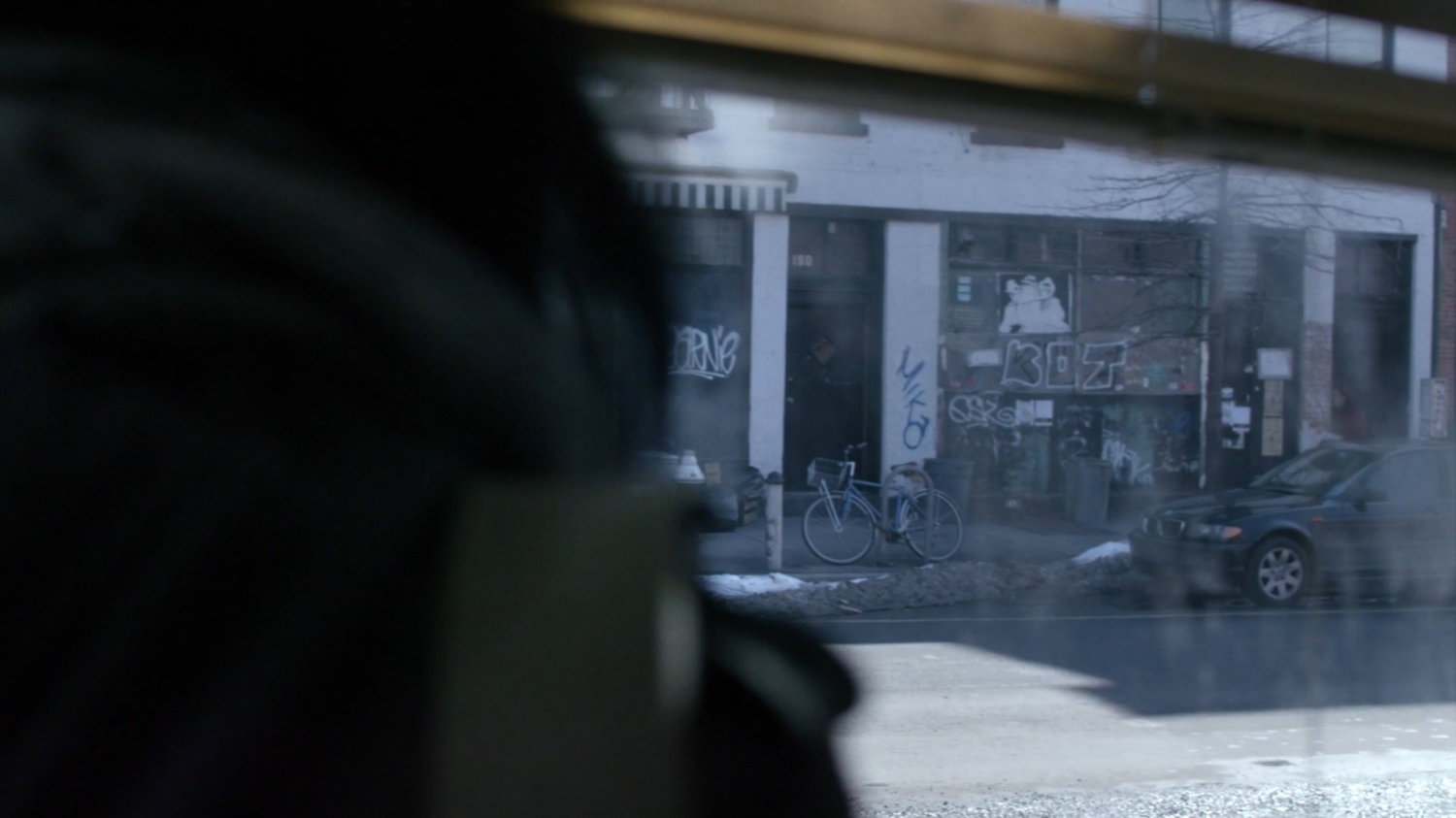 Jessica looking out window at graffiti on wall.
