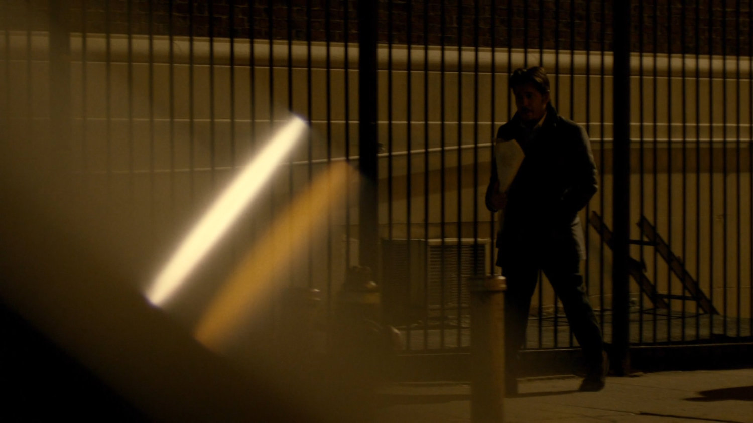 Carlo Eastman walking along sidewalk at nighttime.