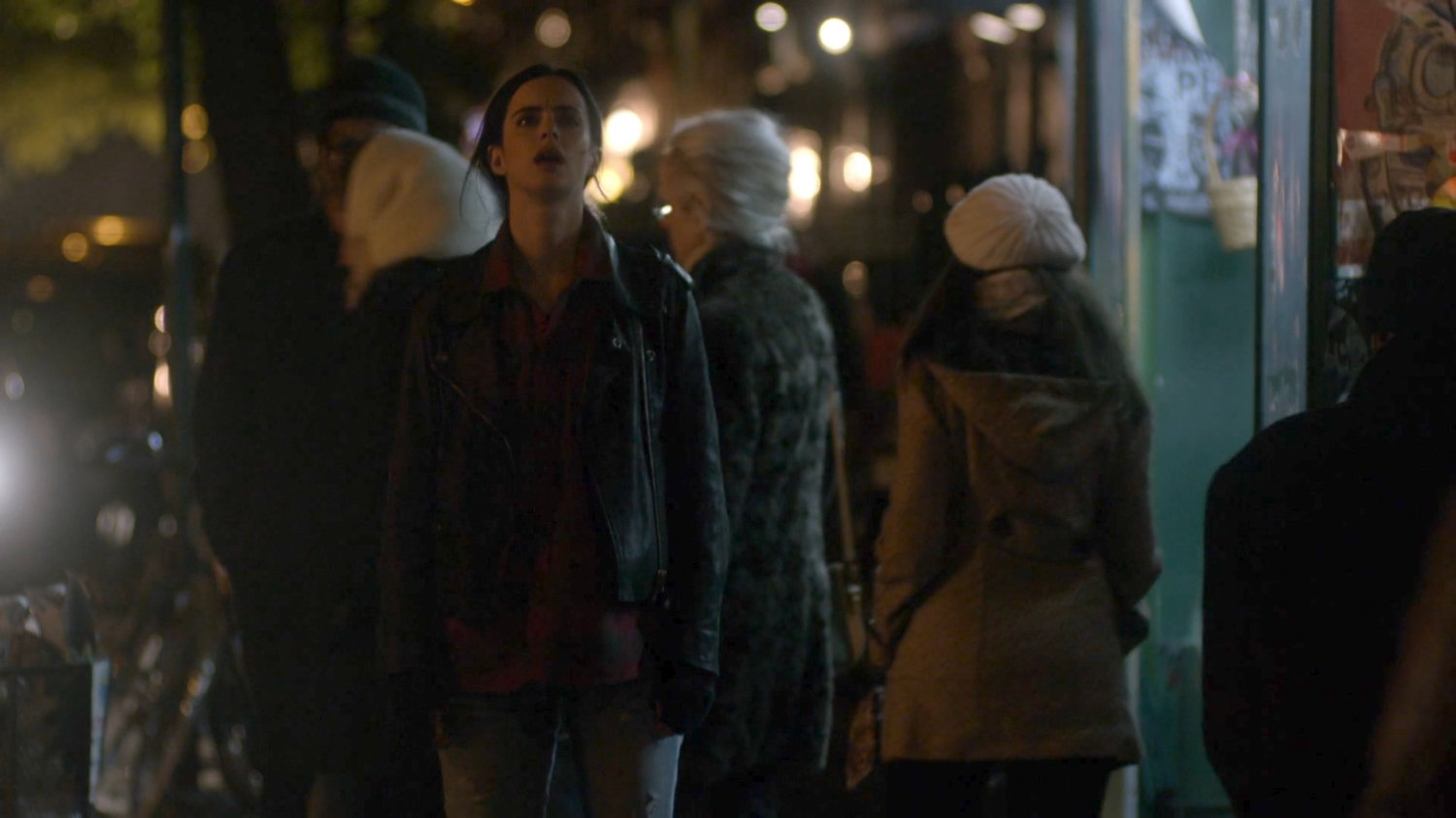 Jessica on a street corner at night.