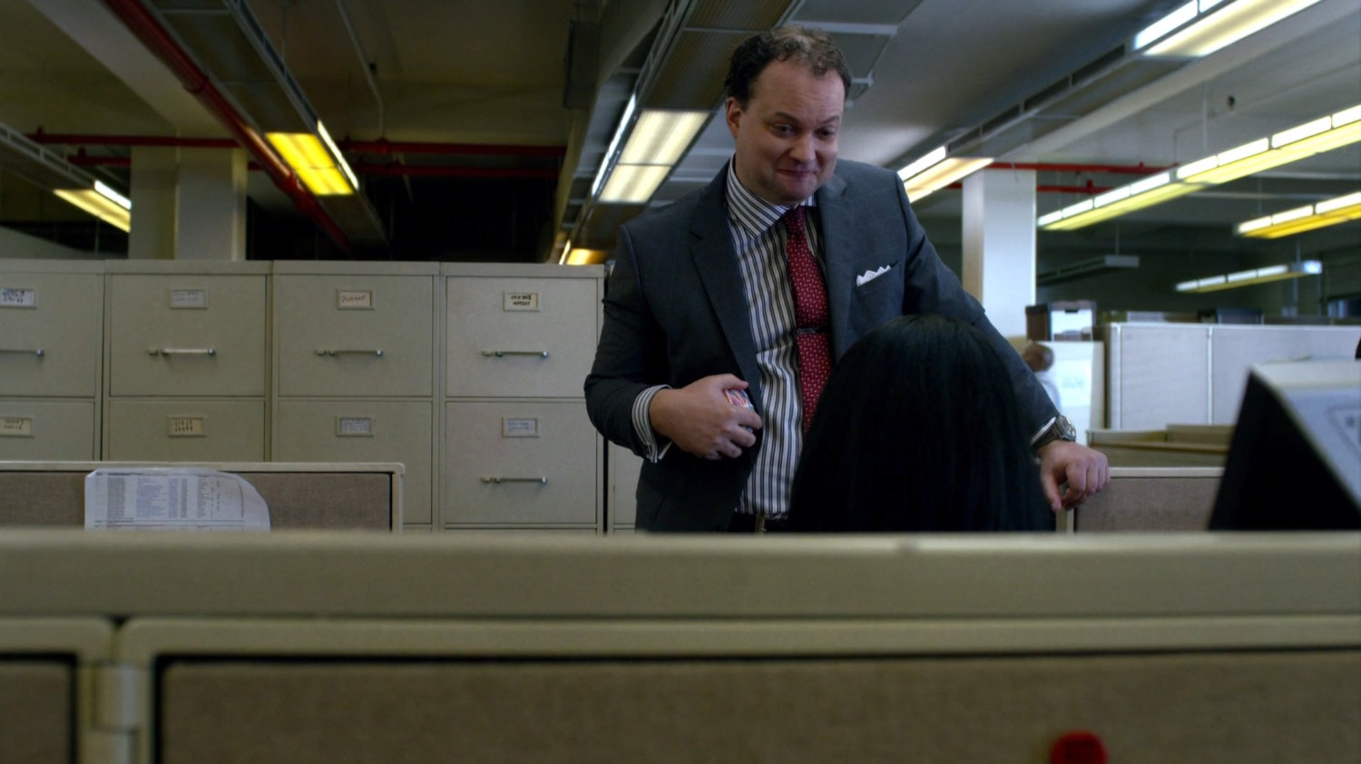 Jessica's boss talks to her at her desk.