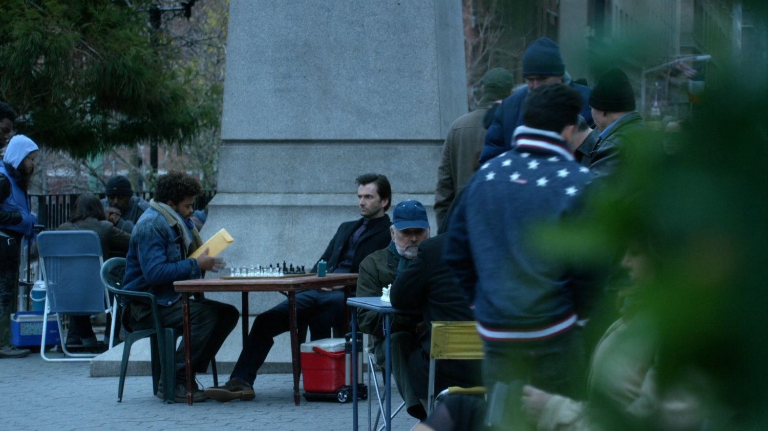 Malcolm at table with Kilgrave in Union Square Park.