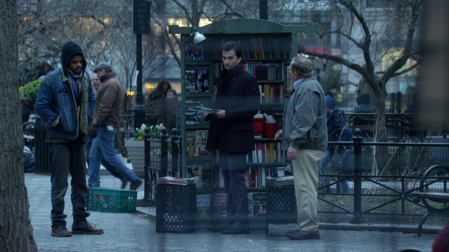 Malcolm at magazine rack with Kilgrave in Union Square Park.