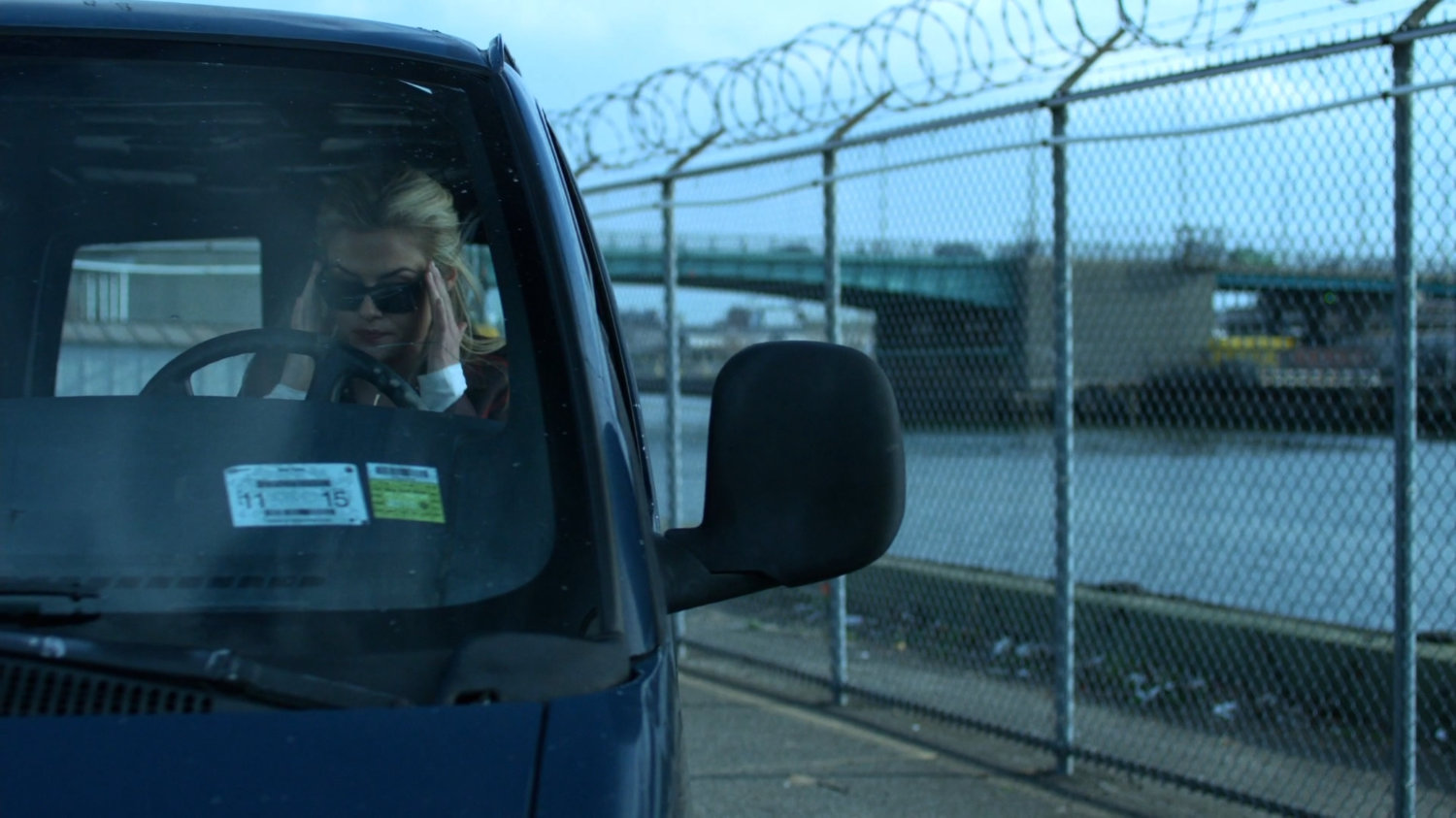 Trish behind the wheel of a van by the river.