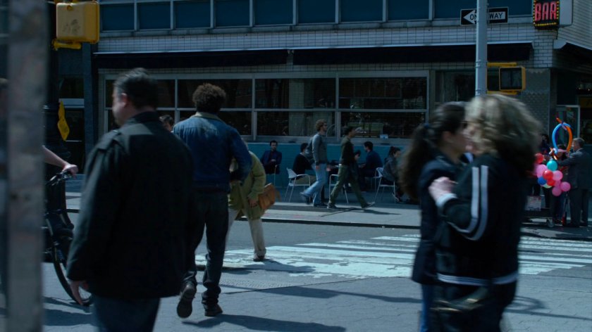 Malcolm crossing street towards coffee shop where Kilgrave is sitting.