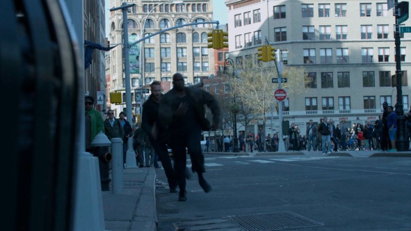 Two bodyguards run after van outside coffee shop.