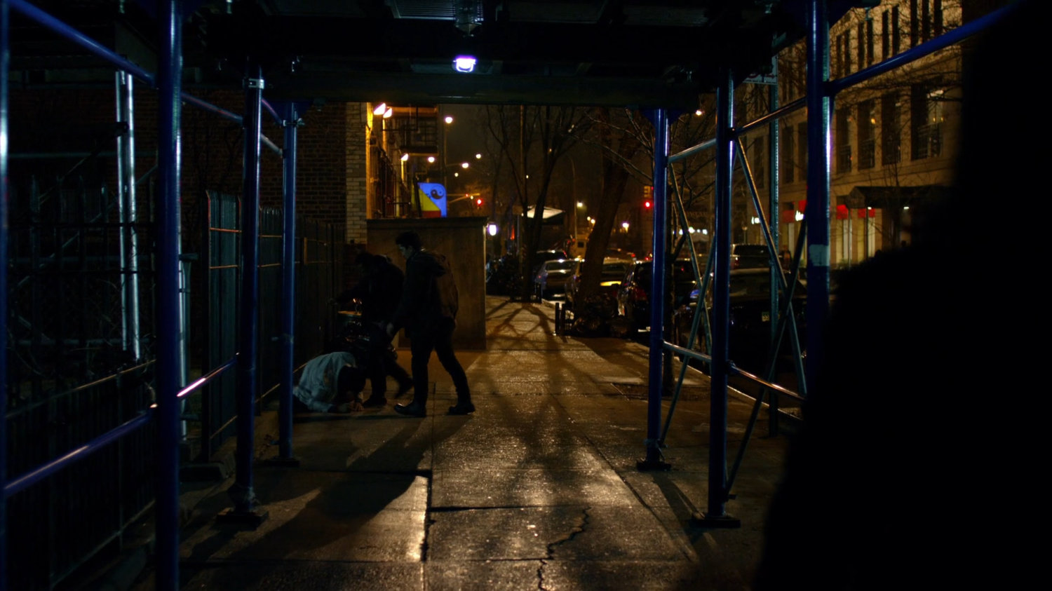 Malcolm getting mugged on sidewalk.