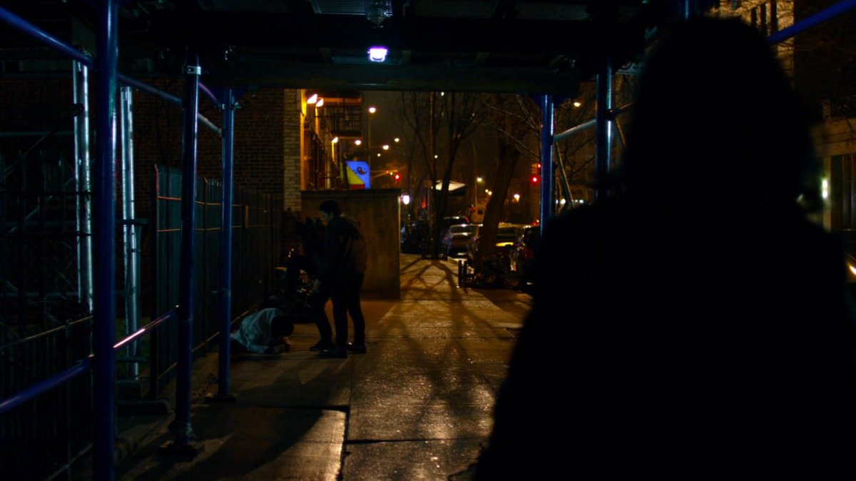 Malcolm getting mugged on sidewalk.