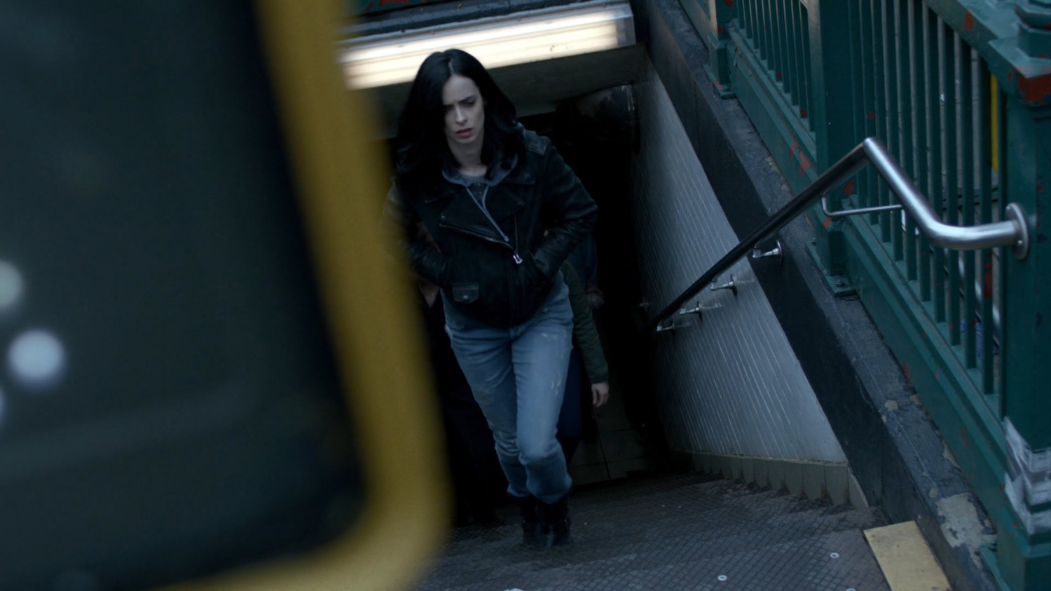Jessica walking up stairs from a subway exit.
