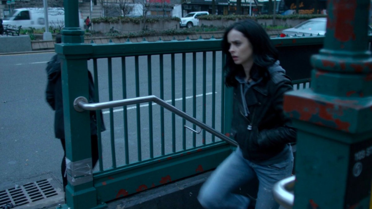 Jessica walking up stairs from a subway exit.