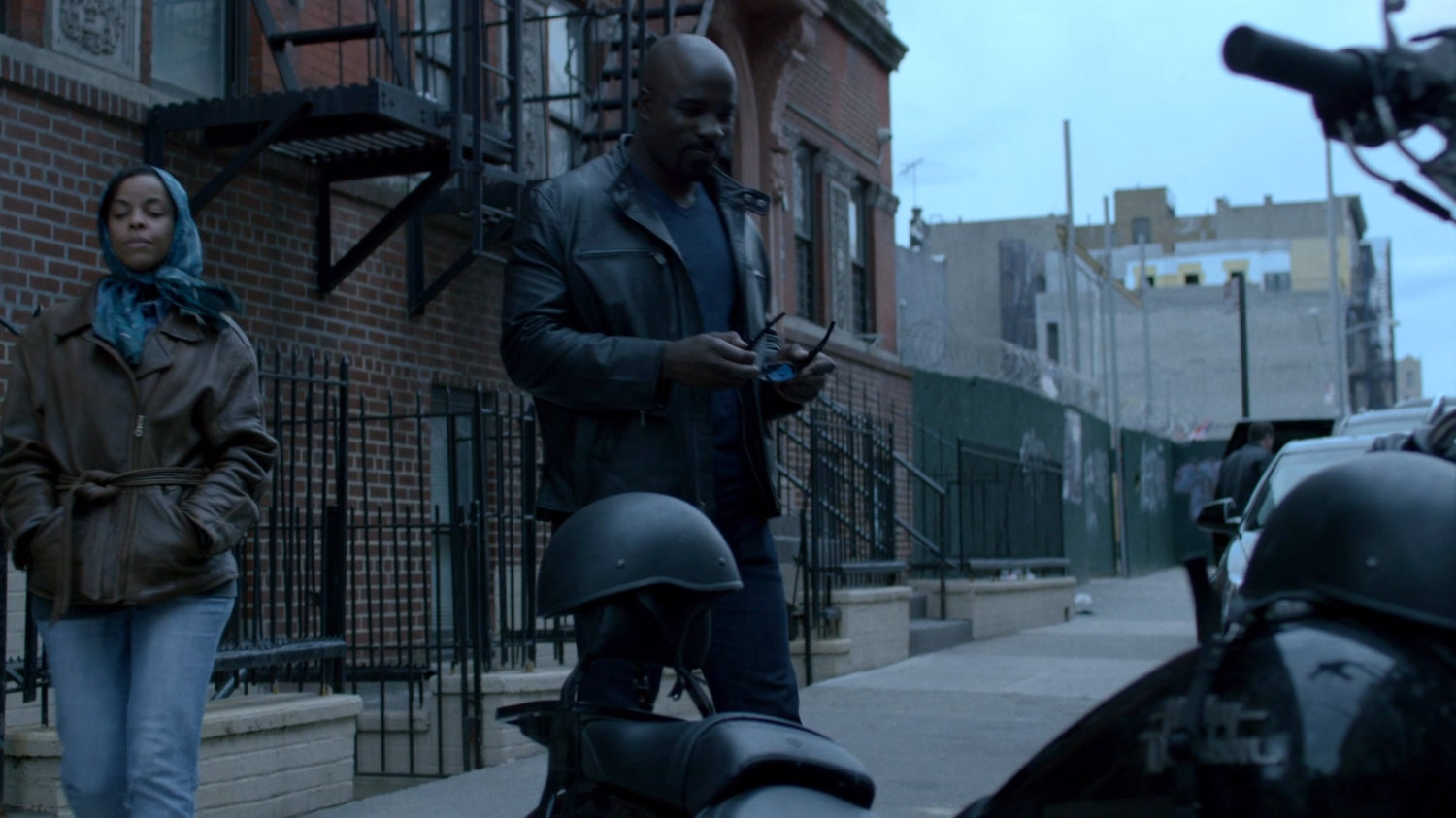 Luke approaching his motorcycle in front of Antoine Grier's apartment building.