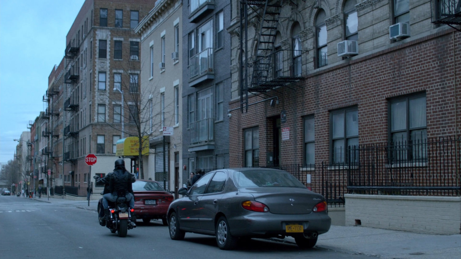 Luke and Jessica on motorcycle riding away from Antoine Grier's apartment building.