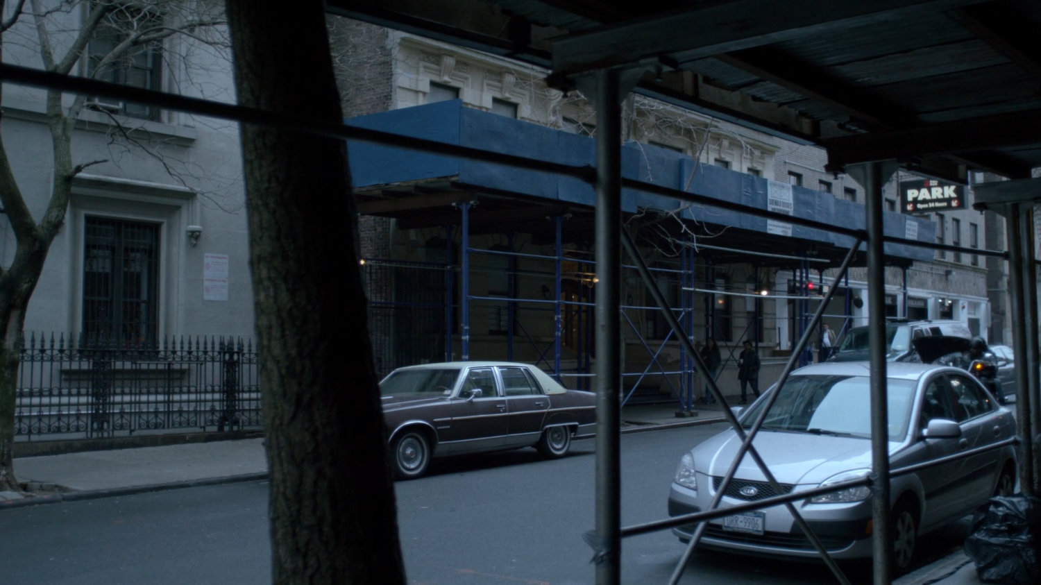 Luke and Jessica on motorcycle pulling up to Alias Investigations building.