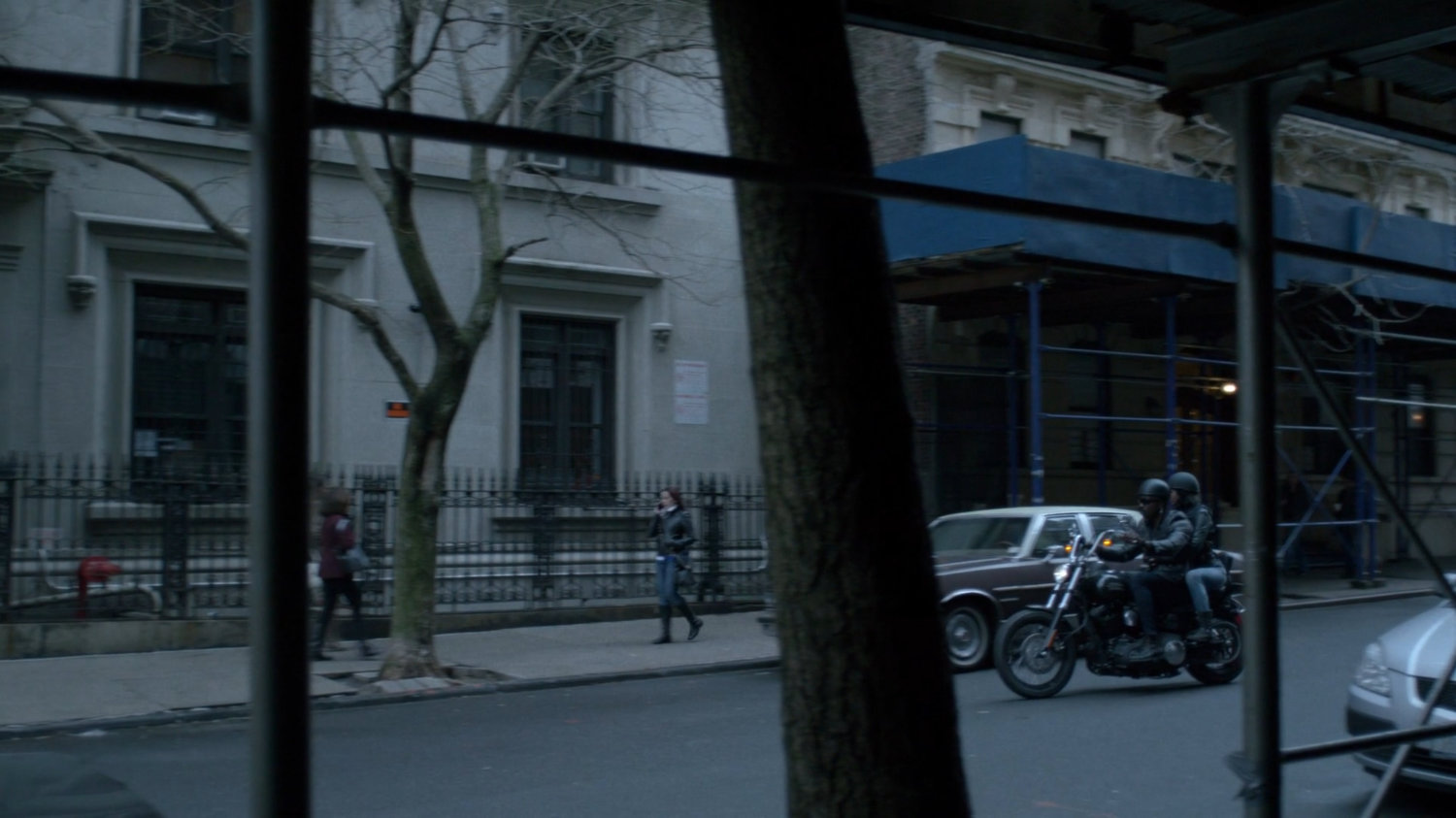Luke and Jessica on motorcycle pulling up to Alias Investigations building.
