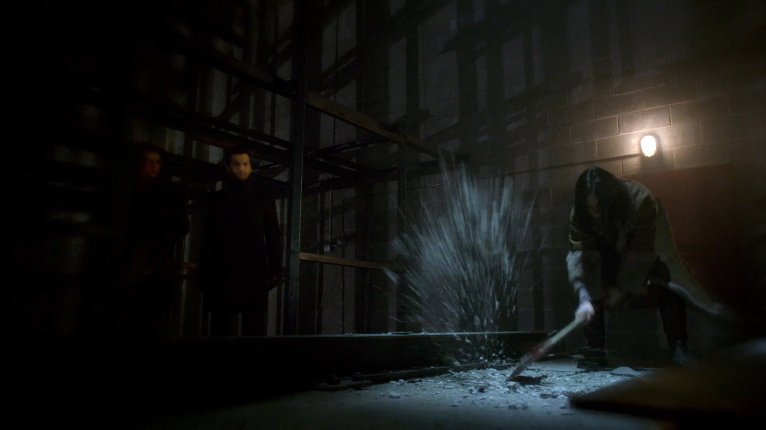 Flashback of Jessica using axe to dig up something in warehouse floor.