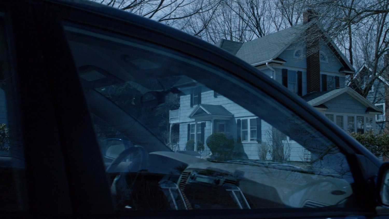 Jessica's childhood home as seen through car windshield.