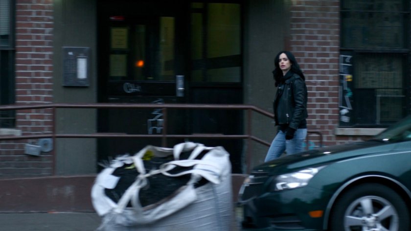 Jessica walking along sidewalk.