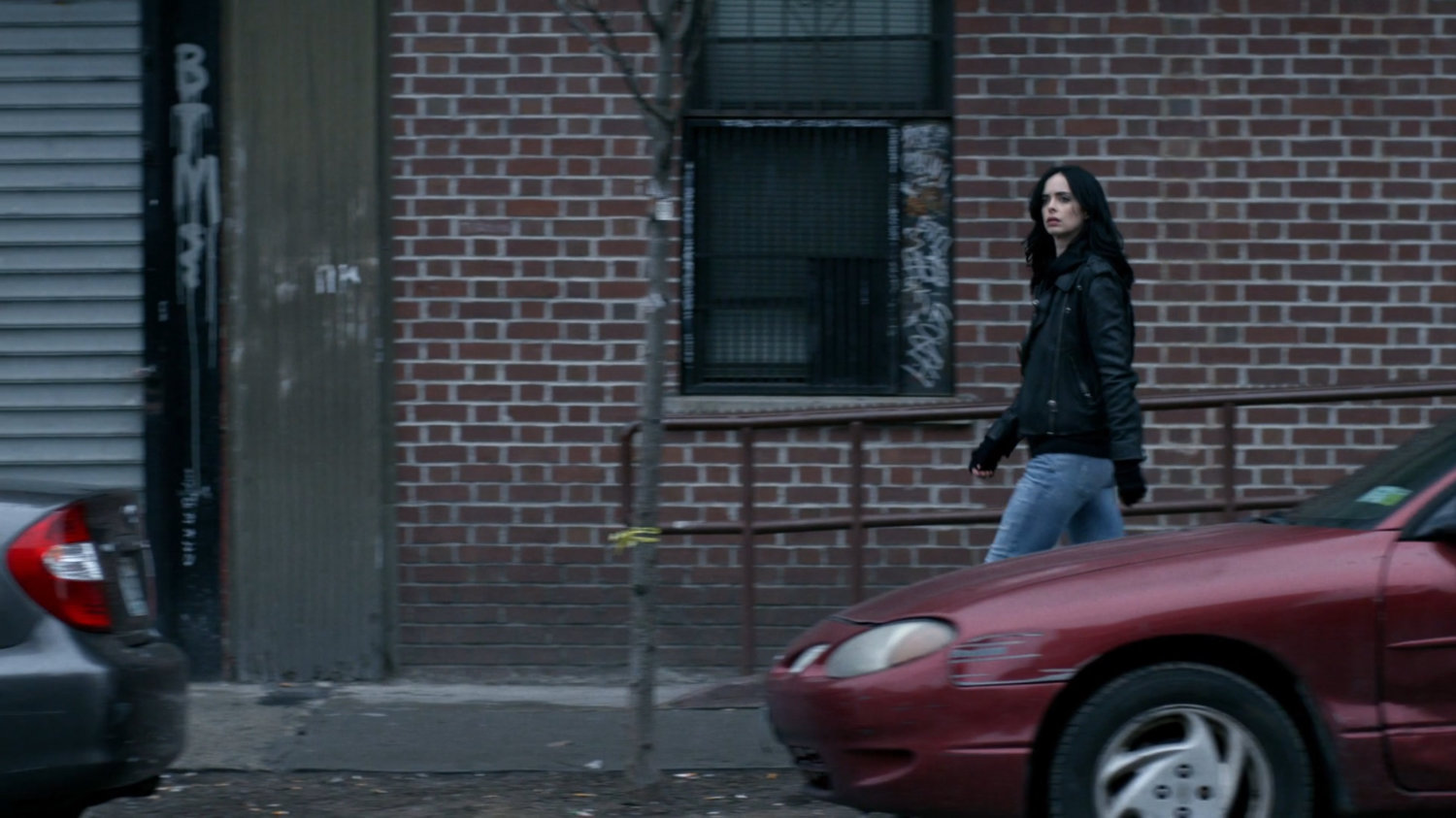 Jessica walking along sidewalk.