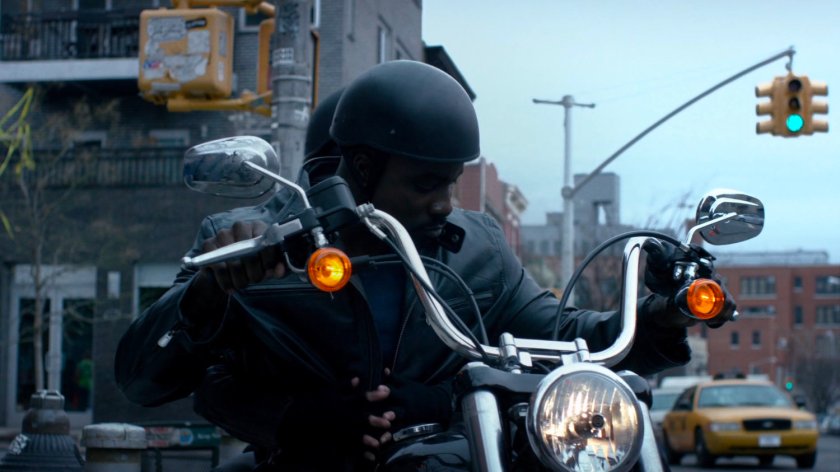 Luke and Jessica riding away from copy shop on motorcycle.
