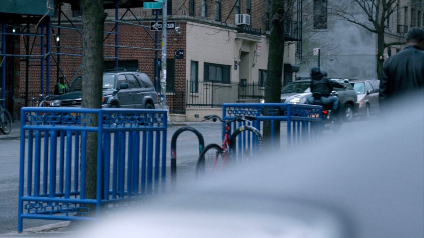 Luke and Jessica following taxi cab on motorcycle.