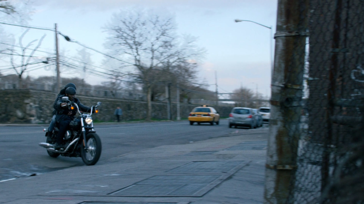 Motorcycle with Luke and Jessica pulling into driveway of warehouse.
