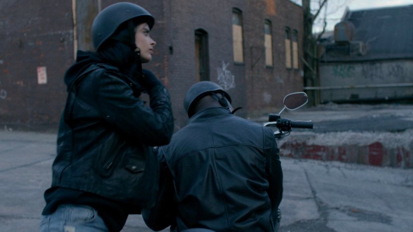 Luke and Jessica taking off their motorcycle helmets.