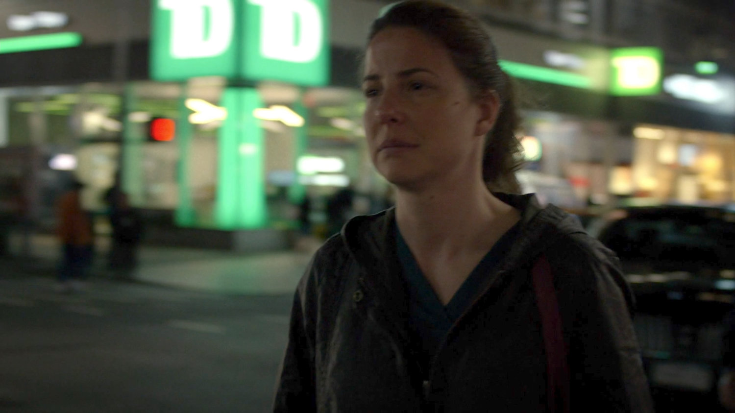 Wendy crossing a street at night.
