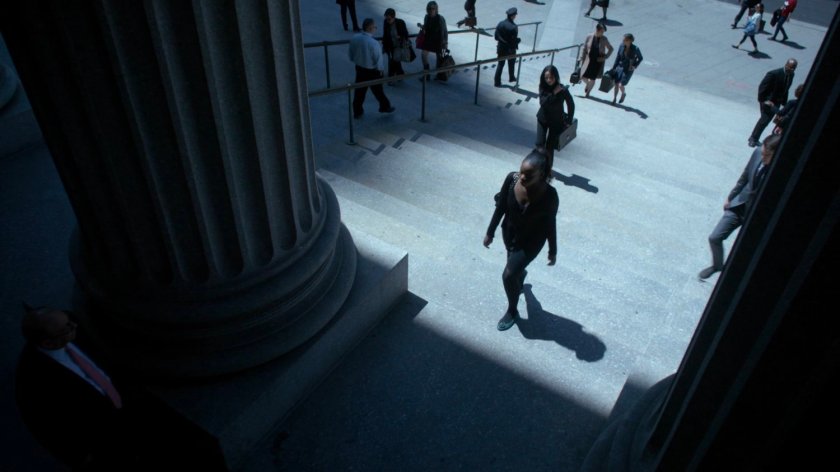 Pedestrians walking up steps towards courthouse.