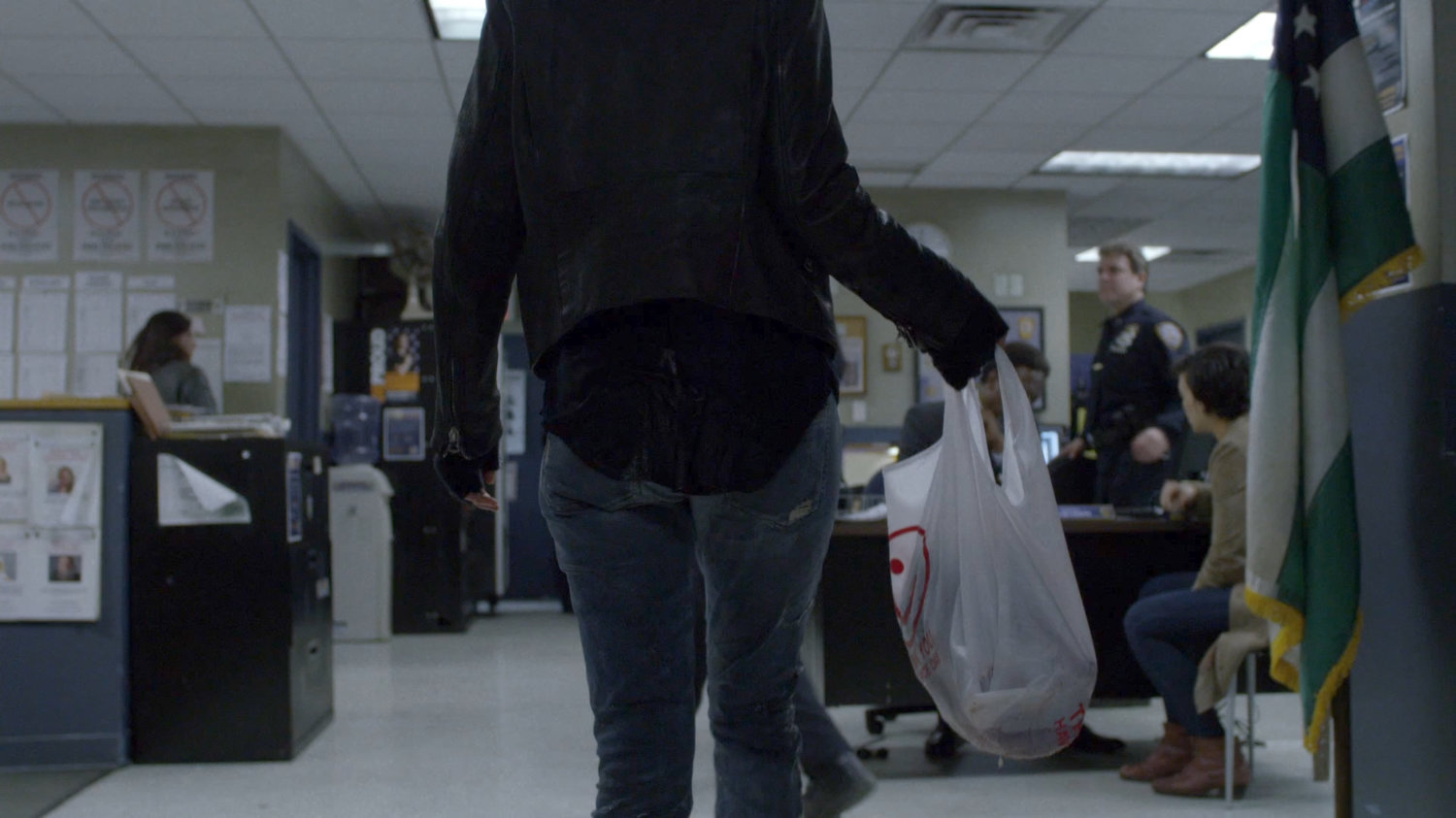 Jessica in the 15th Precinct police station with a plastic bag.