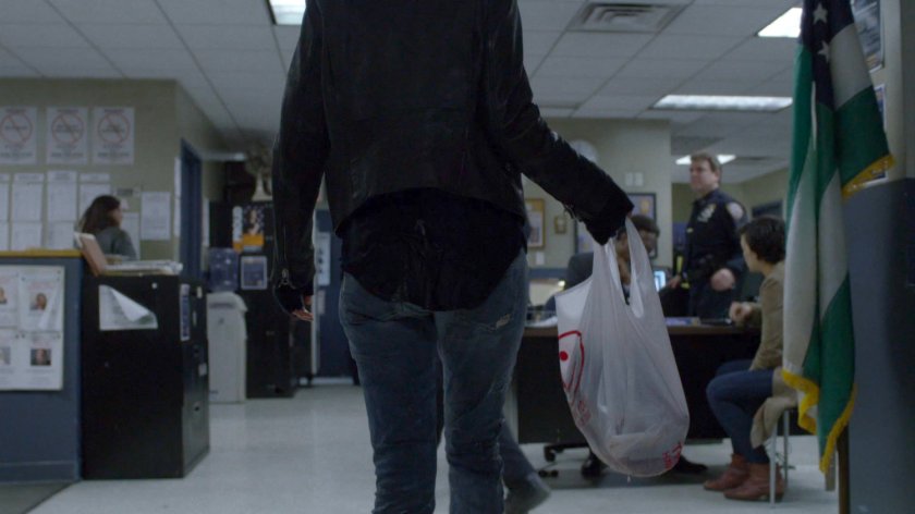 Jessica in the 15th Precinct police station with a plastic bag.