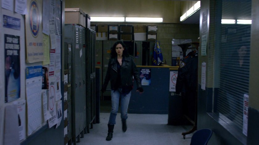 Jessica walking past the booking desk in the 15th Precinct police station.