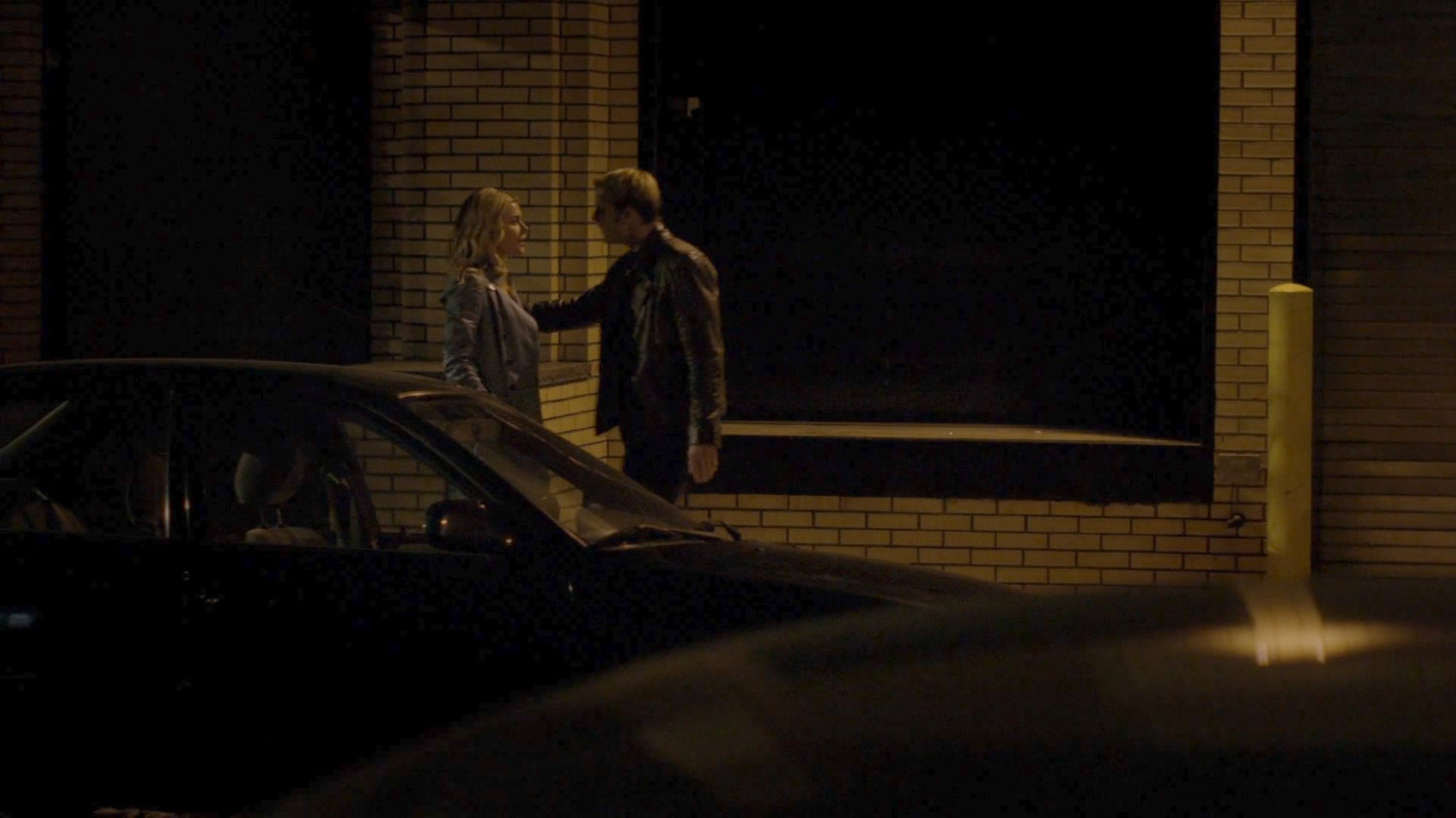 Simpson and Trish walk along a sidewalk at night.