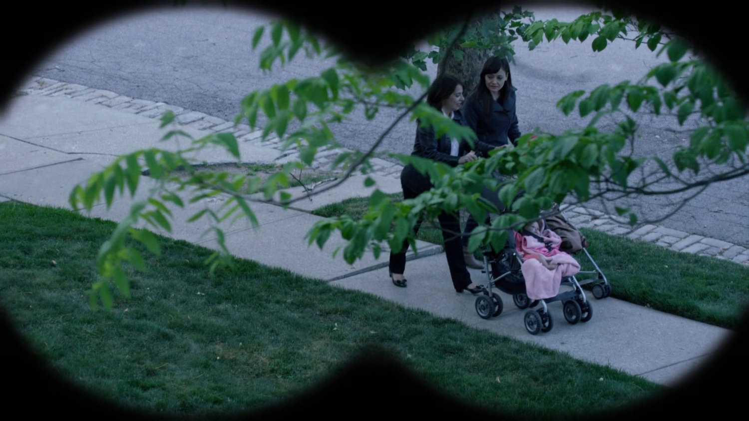 Two women push a baby stroller on sidewalk outside Jessica's childhood home.