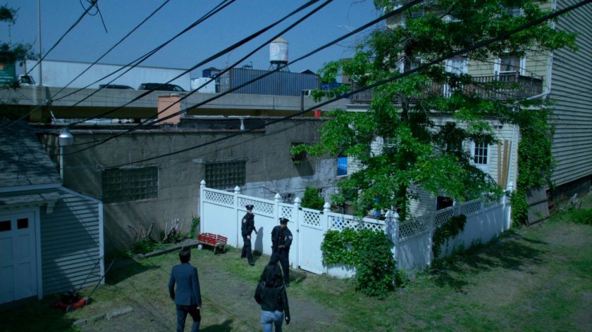 Jessica and Kilgrave walk through a backyard at a hostage situation.