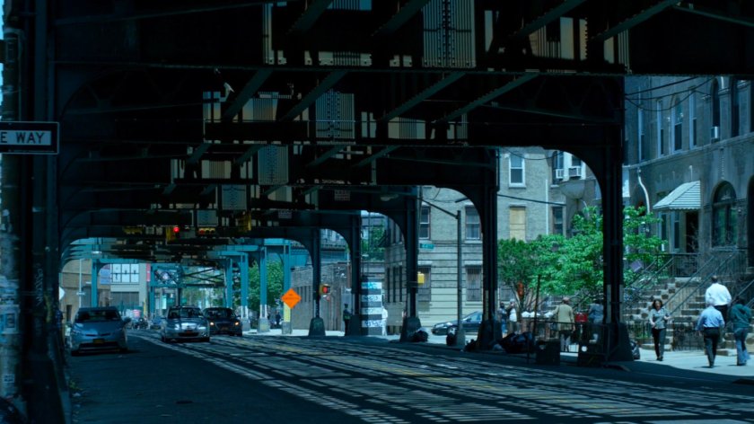 Trish's car speeding through city streets under overpass.