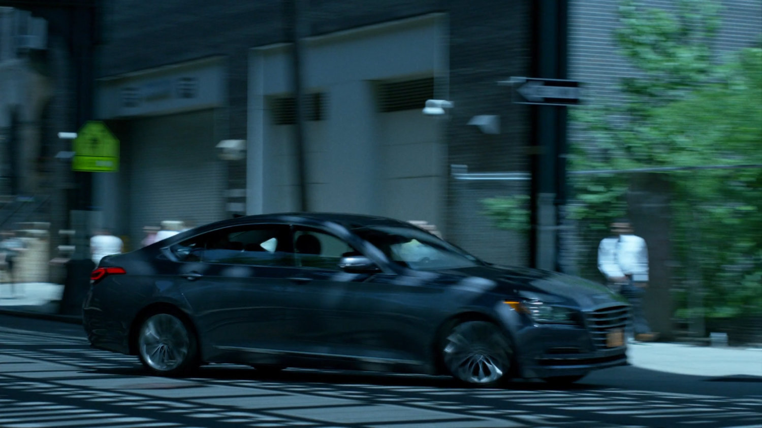 Trish's car speeding through city streets under overpass.