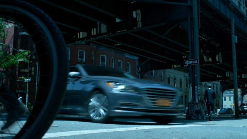 Trish's car speeding through city streets under overpass.