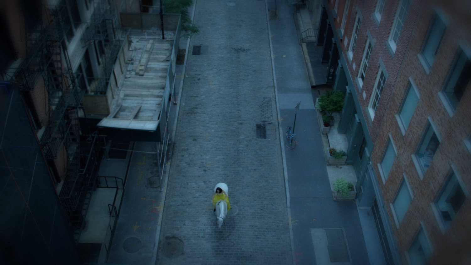 Flashback of Jessica riding white horse on street near fancy apartment.