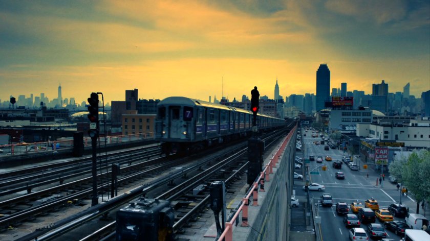 Elevated train drives along tracks at sunrise in New York.