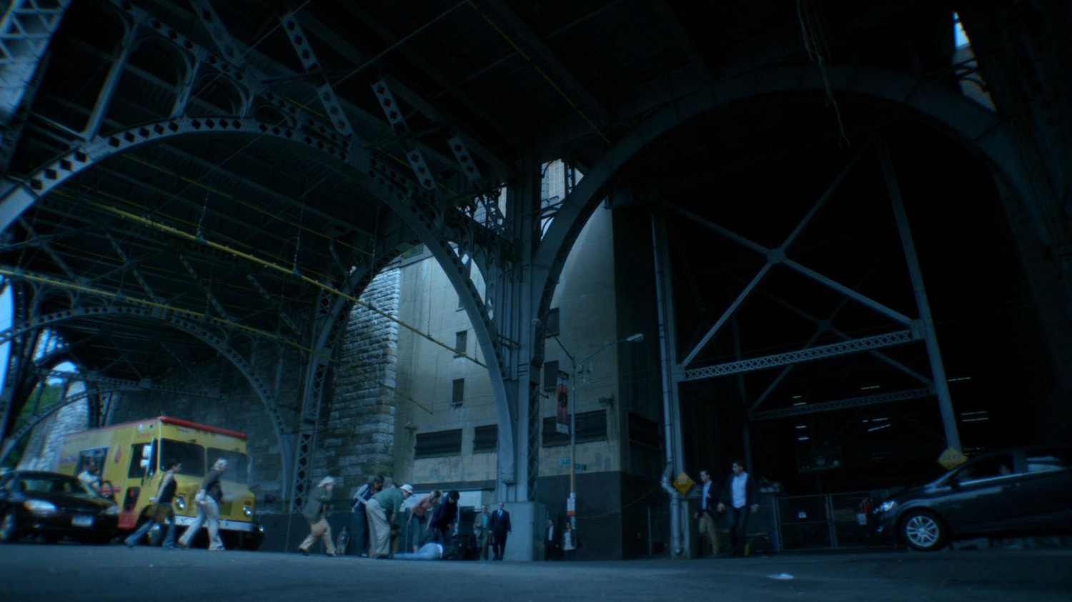 Crowd gathers under overpass.