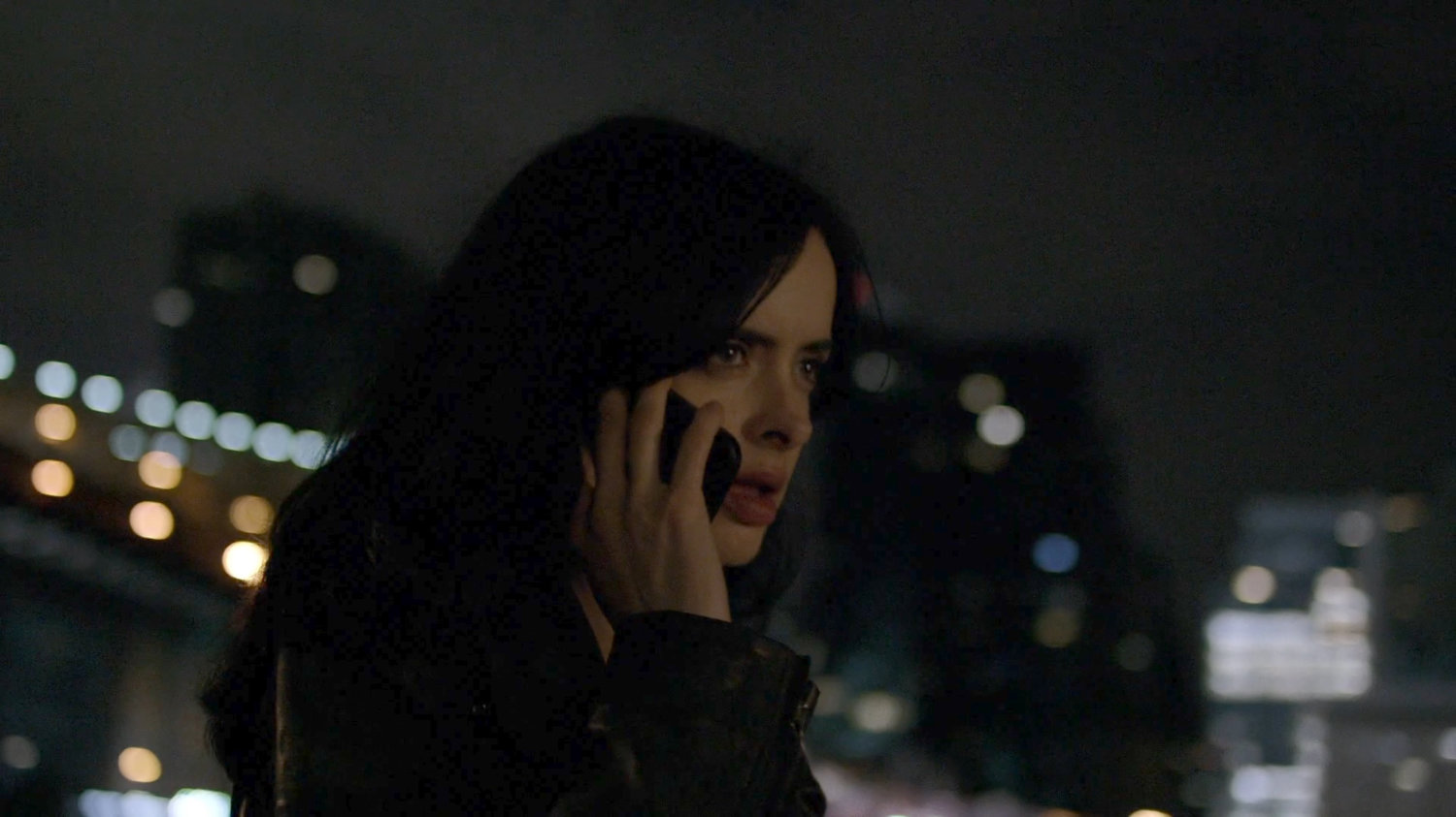 Jessica on phone by river at night.
