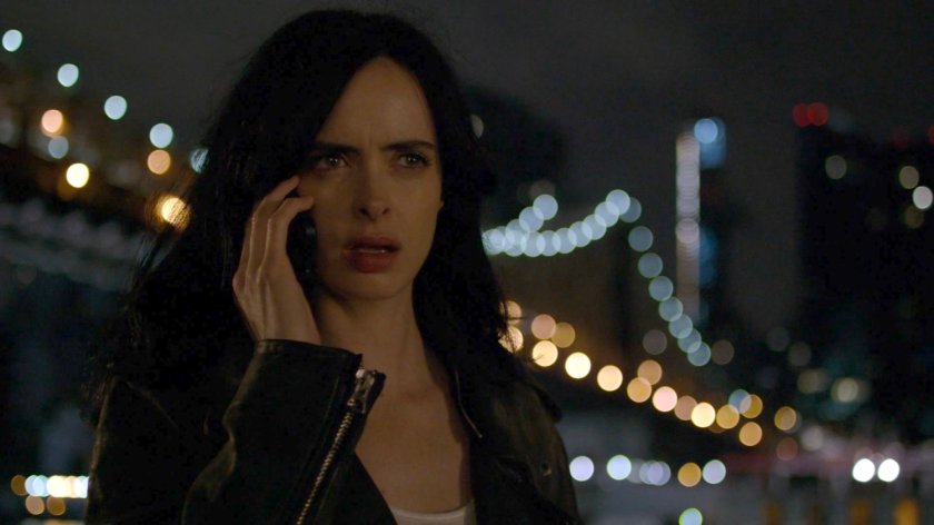 Jessica on phone by river at night.