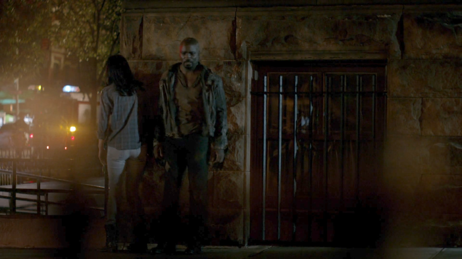 Luke and Jessica hiding around the corner from Luke Cage's bar.